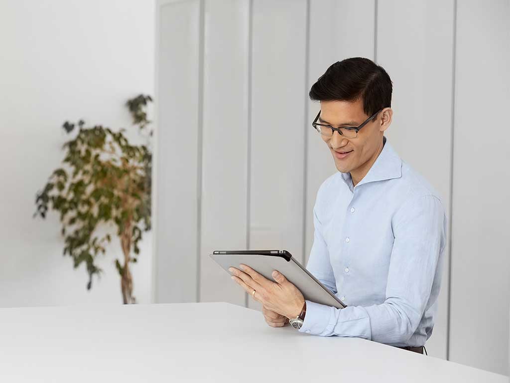 Smiling man using ipad at table