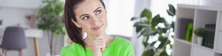 Woman thinking with her hand on her chin and eyes looking up