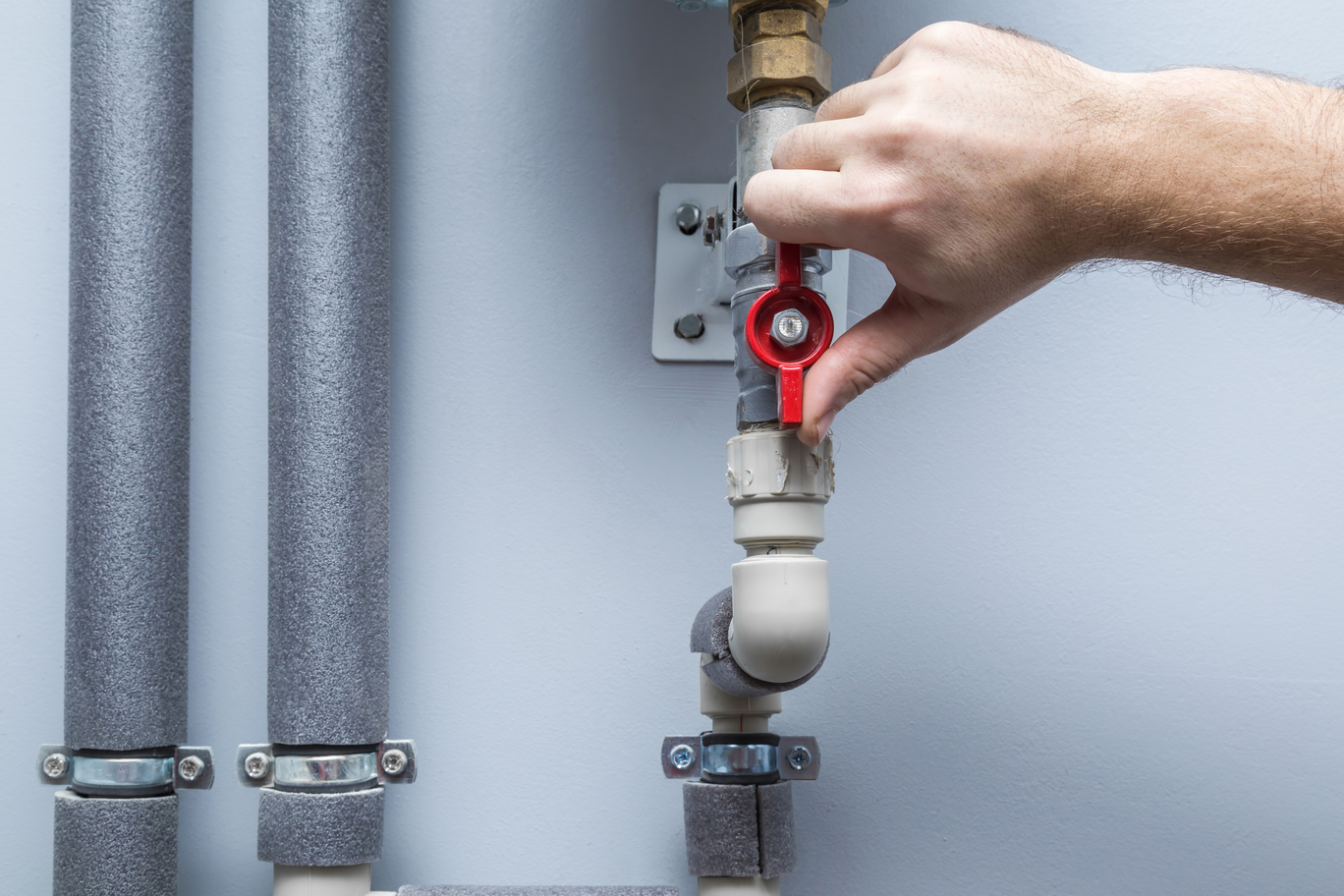 man turning handle on pipes