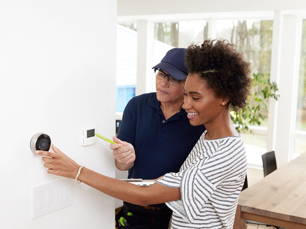 lady-with-repairman-looking-at-nest-unit