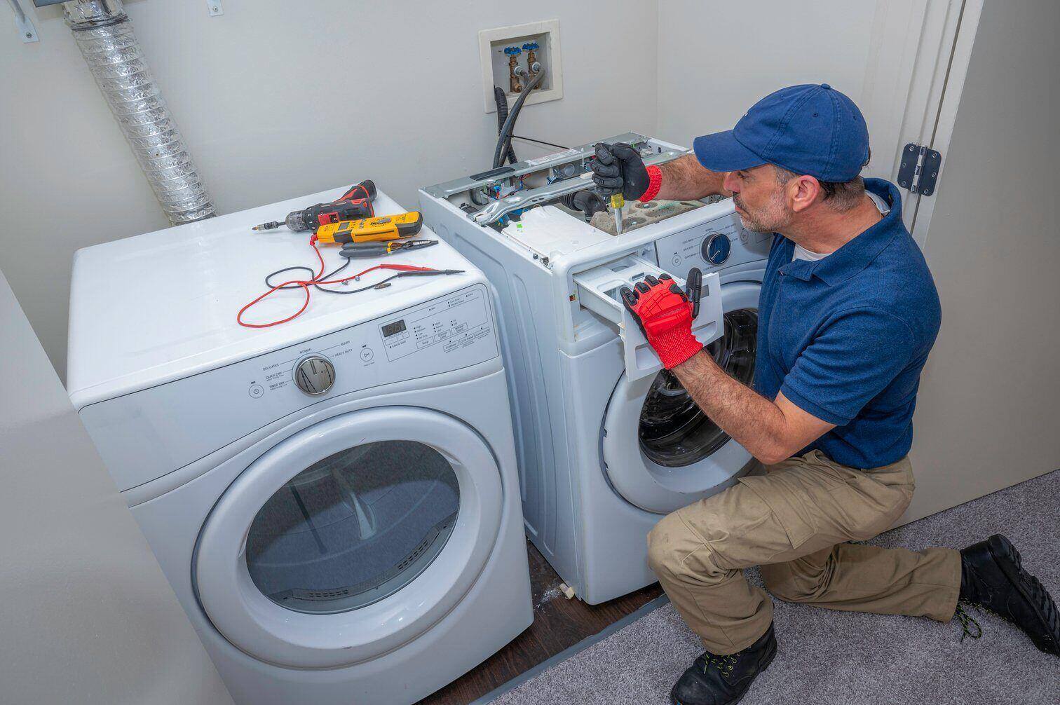 A service technician repairing a broken washing machine